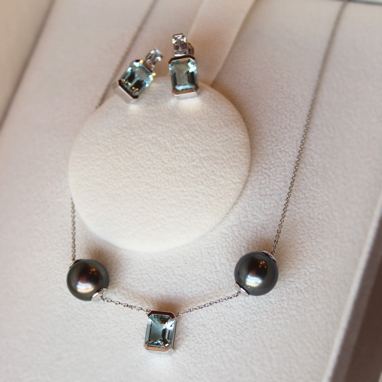 Bespoke aquamarine pendant and earrings set featuring emerald-cut aquamarines and repurposed Tahitian pearls.