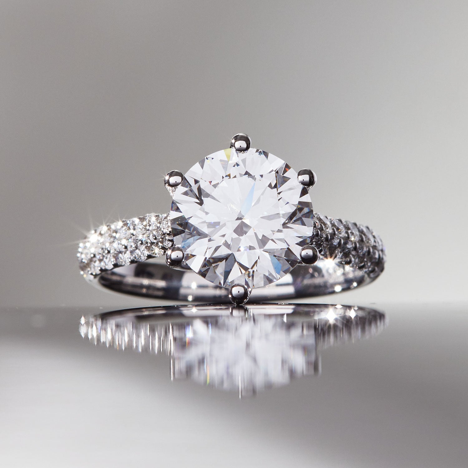Faith Jewels Arlene diamond engagement ring featuring a 3ct round brilliant-cut solitaire diamond in a twist-setting with an asymmetrical pavé diamond band
