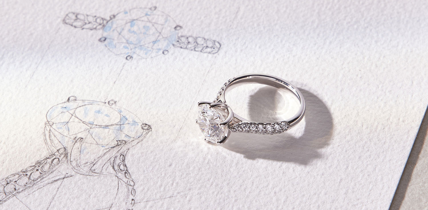 Arlene diamond engagement ring with a floating round brilliant-cut diamond in a twist-setting, accented by an asymmetrical pavé diamond band