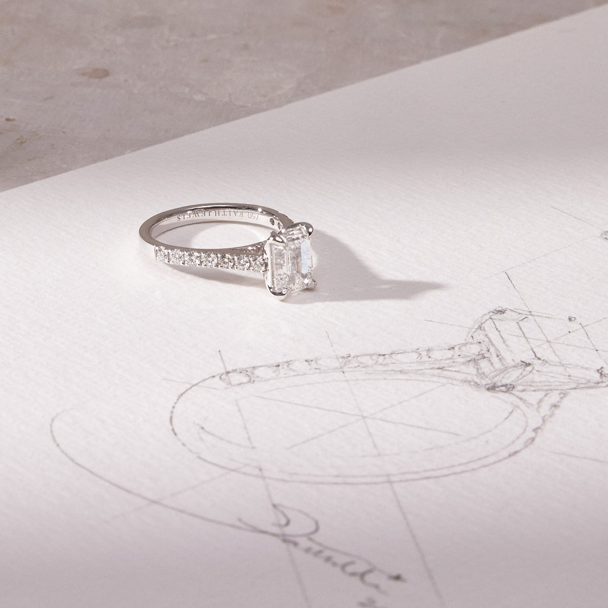 Faith Jewels ring with engraving lying next to a design drawing by Faith Hilda