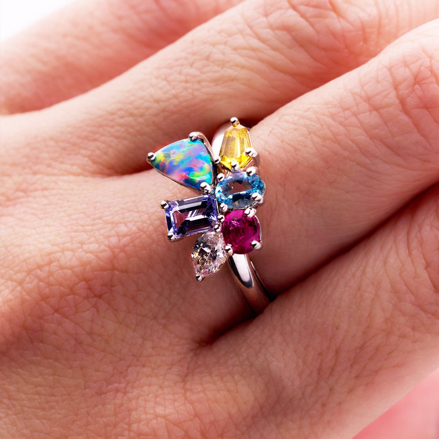Hazel birthstone white gold band ring featuring aquamarine, diamond, opal, ruby, citrine, and tanzanite arranged in a colourful design, symbolizing family