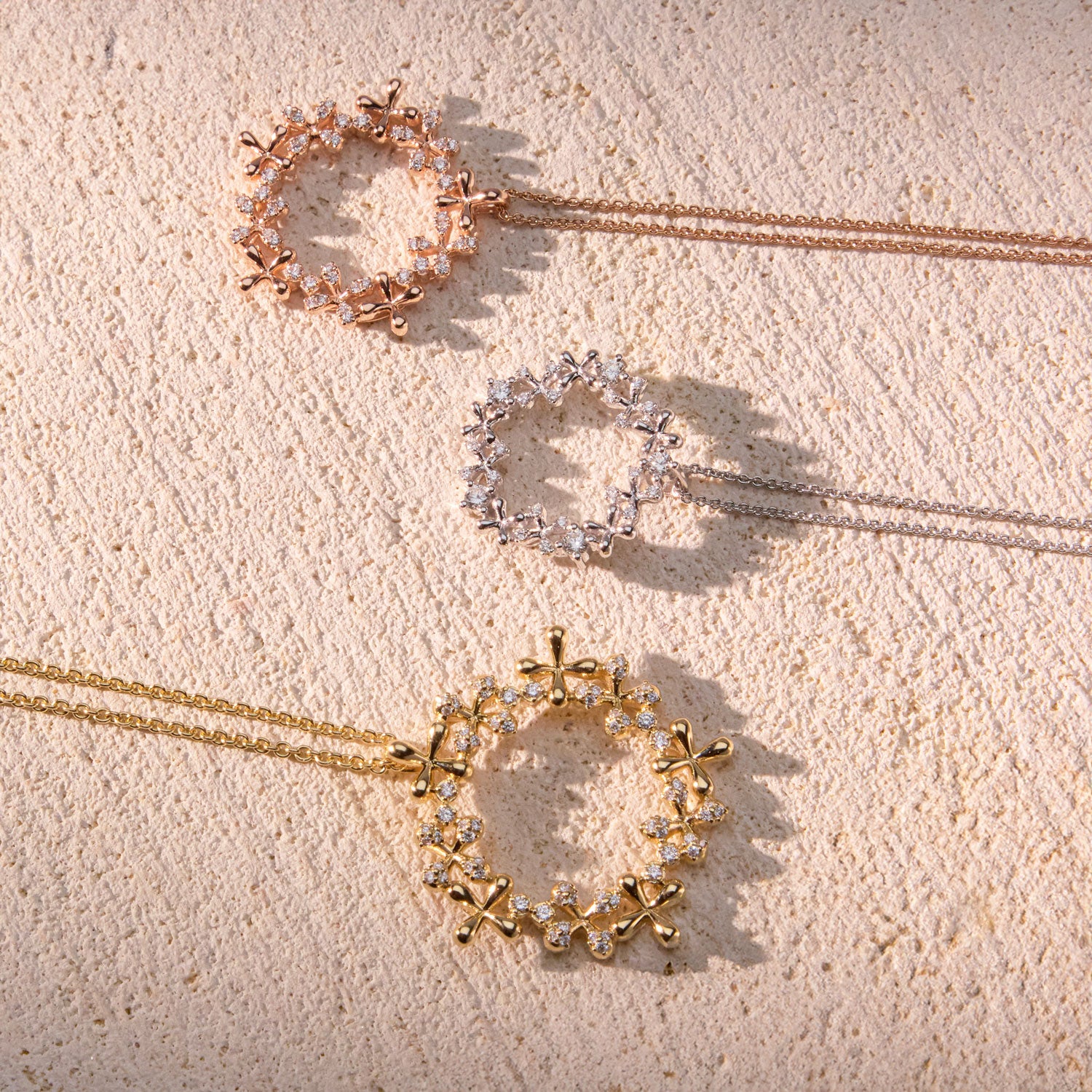 White, yellow and rose gold wreath pendant with diamonds in a floral circular design, on a 45cm chain.