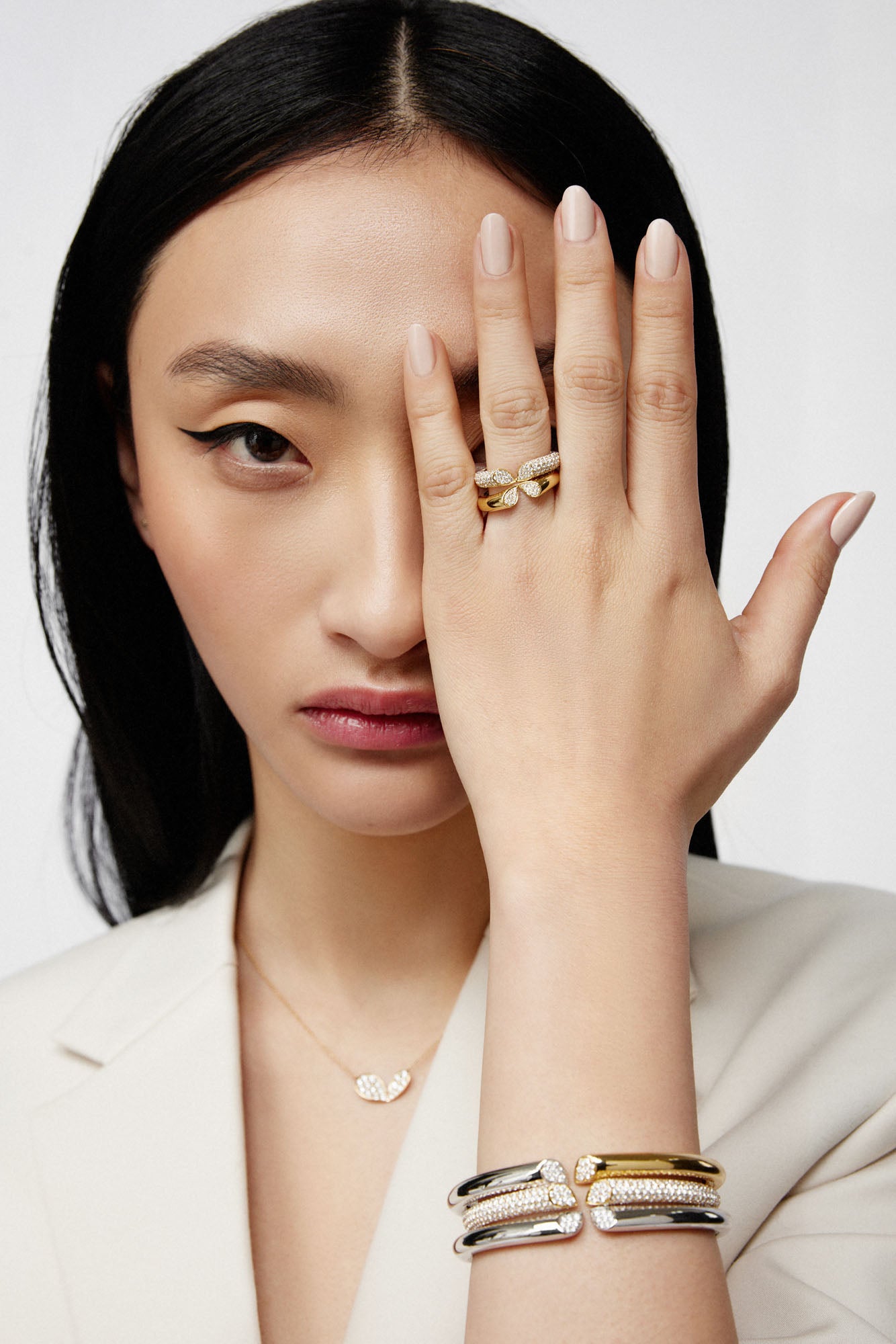 Faith Jewels 18k yellow and white gold bangle with 6.00ct pavé diamonds, featuring a heart-shaped lily petal design and secure hinge closure, worn with matching rings and necklace