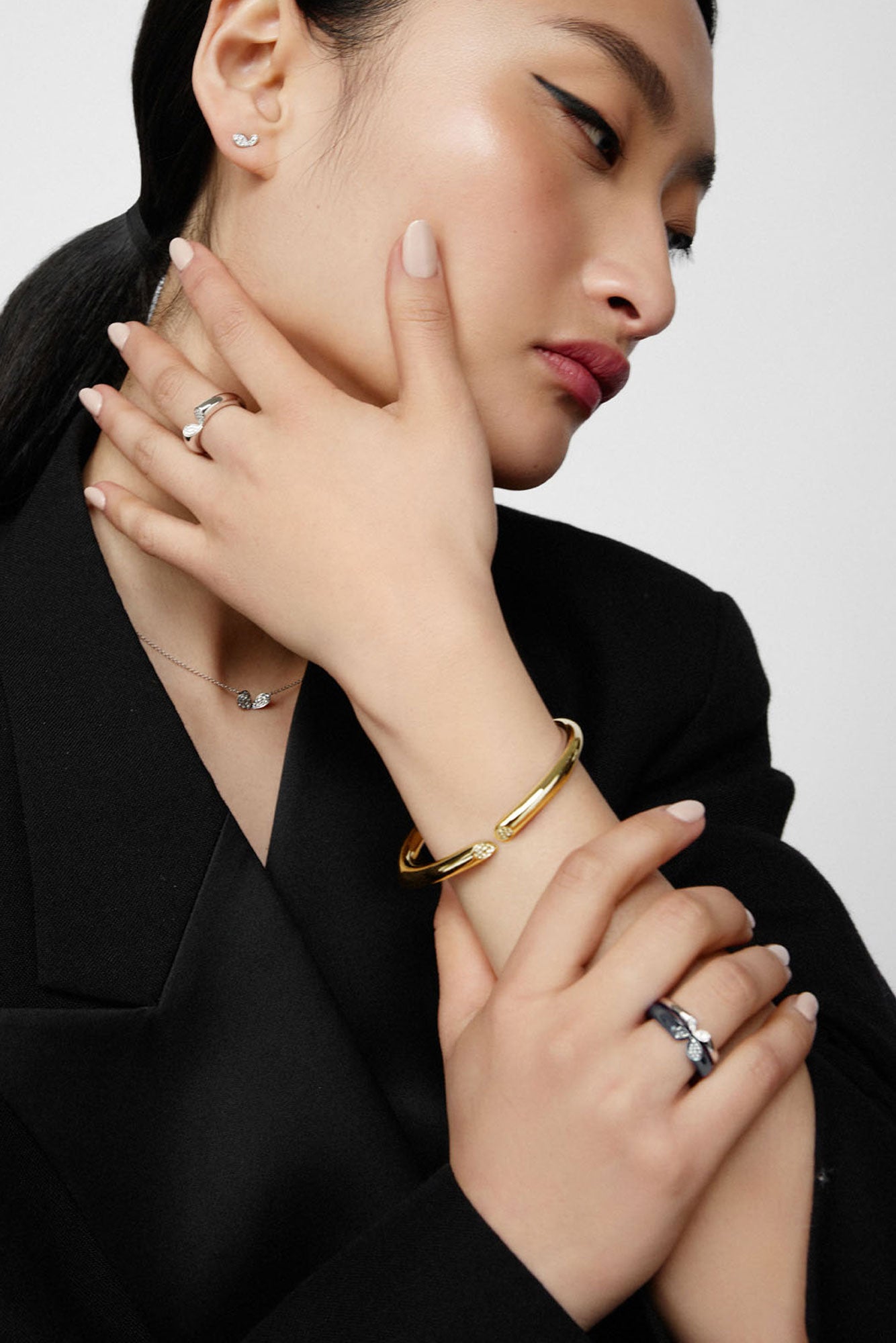 Faith jewels whispers of love collection white gold mini stud earrings worn with matching white gold pendant necklace, stacked rings and yellow gold bangle