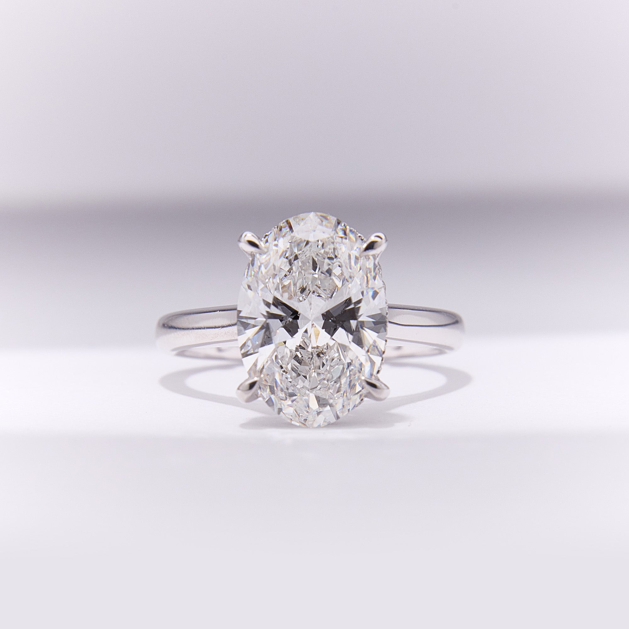 18k white gold engagement ring with 3.72ct oval-cut diamond, elegant band, combining timeless sophistication and contemporary design.