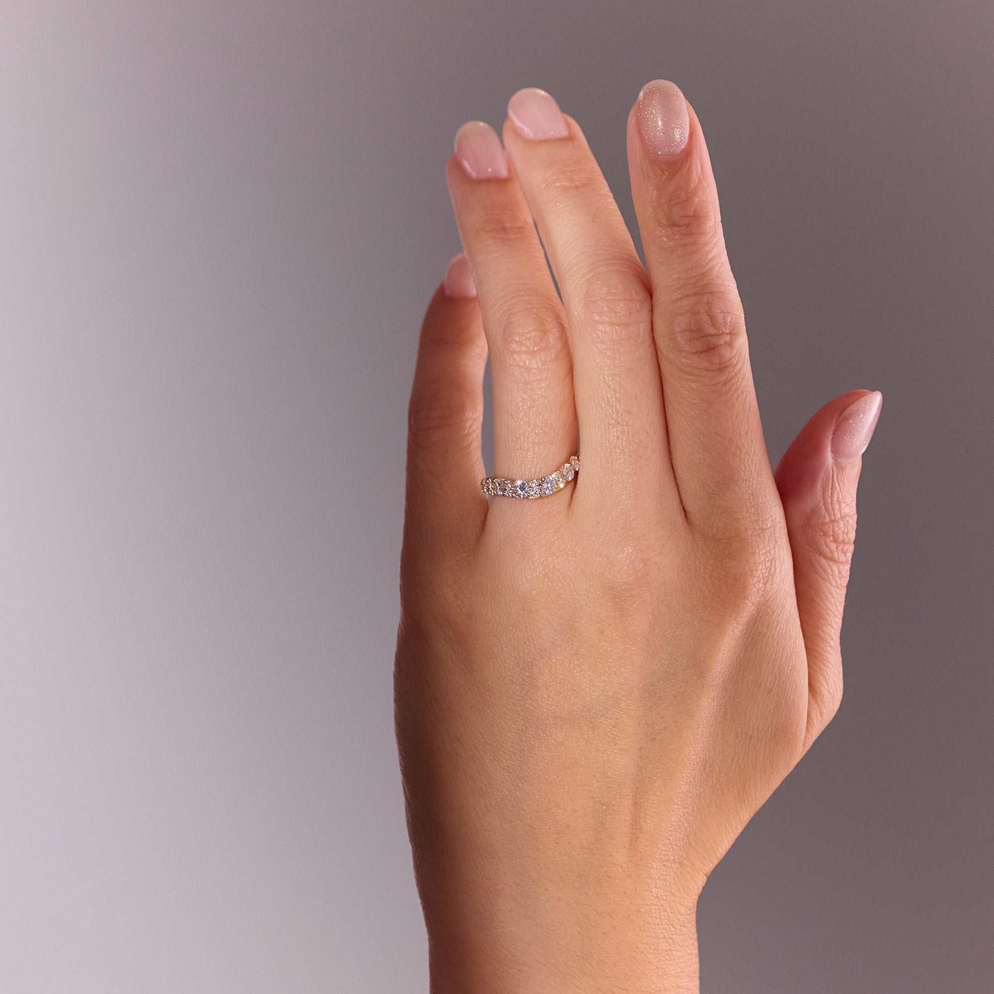 Arc Diamond Wedding Band in yellow gold, repurposed diamonds from original ring, curved design inspired by Eclipse Ring, elegant contour fit. Worn on hand model.