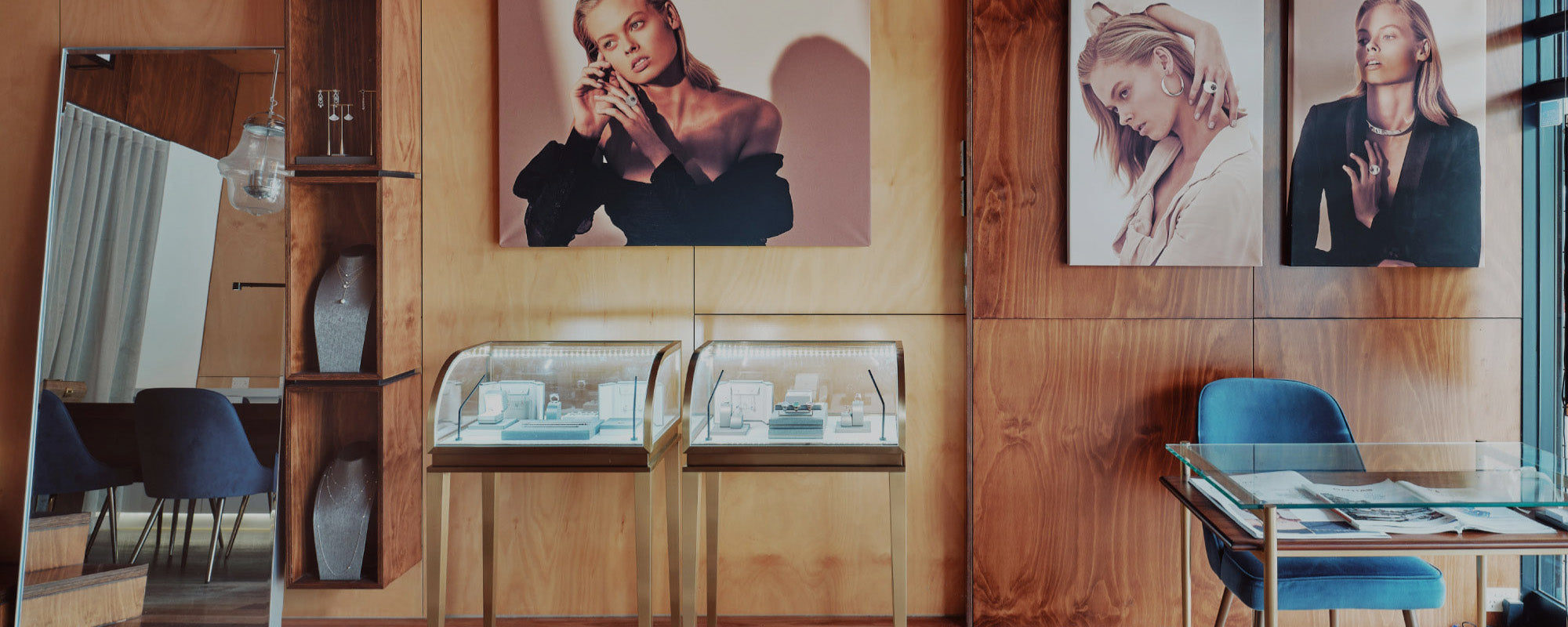 Display case with jewellery at the melbourne design studio of Faith Jewels showing a room with wooden walls and a mirror.