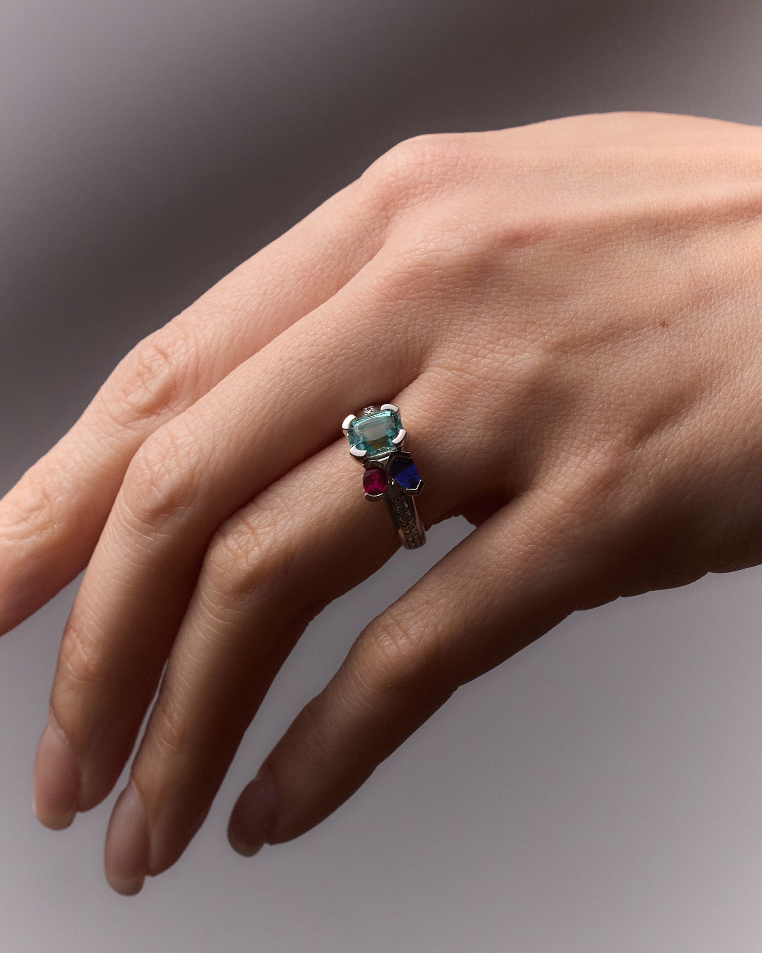 White gold Kelly Bouquet ring featuring ruby, Paraiba tourmaline, blue sapphire, and diamond accents.