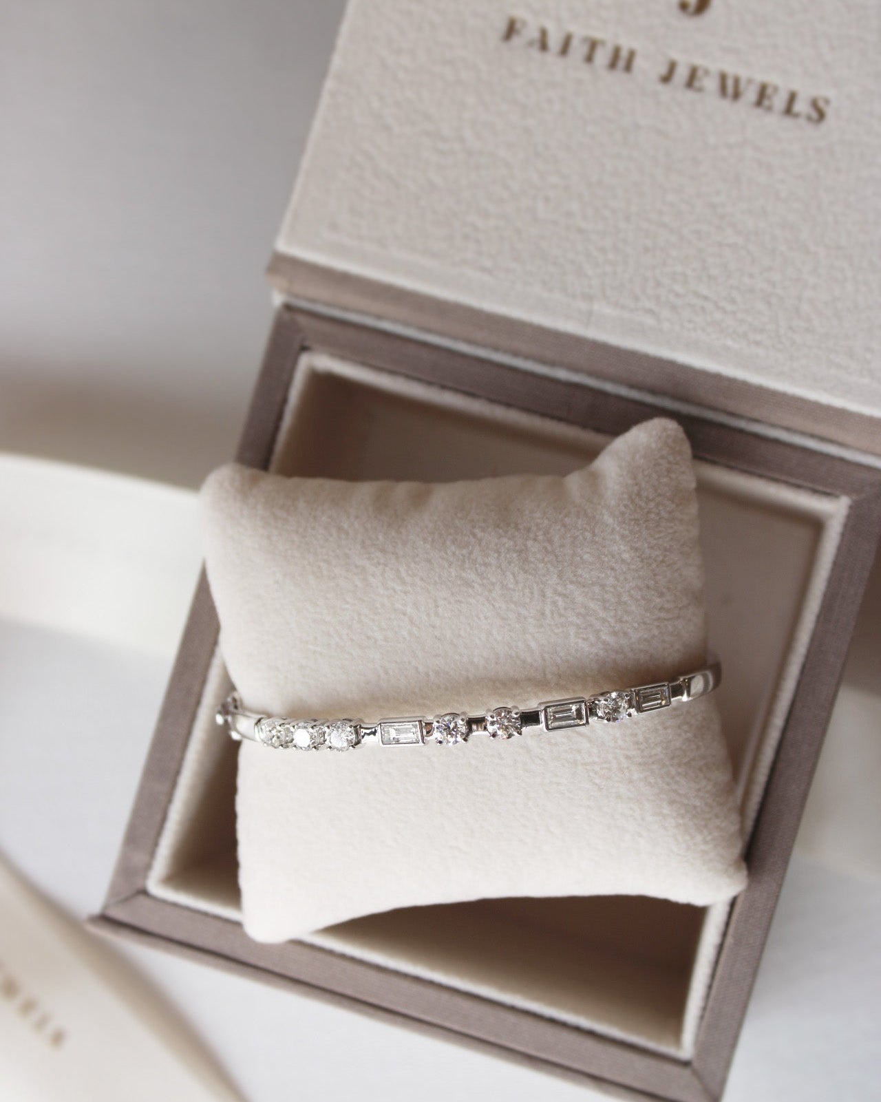Elegant white gold Kirsty bangle with round and baguette diamonds forming Morse code initials.