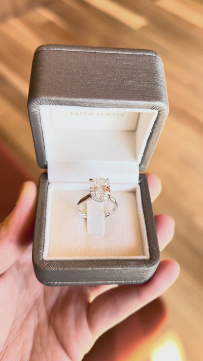 18k white gold engagement ring with 3.72ct oval-cut diamond, elegant band, with hidden halo.