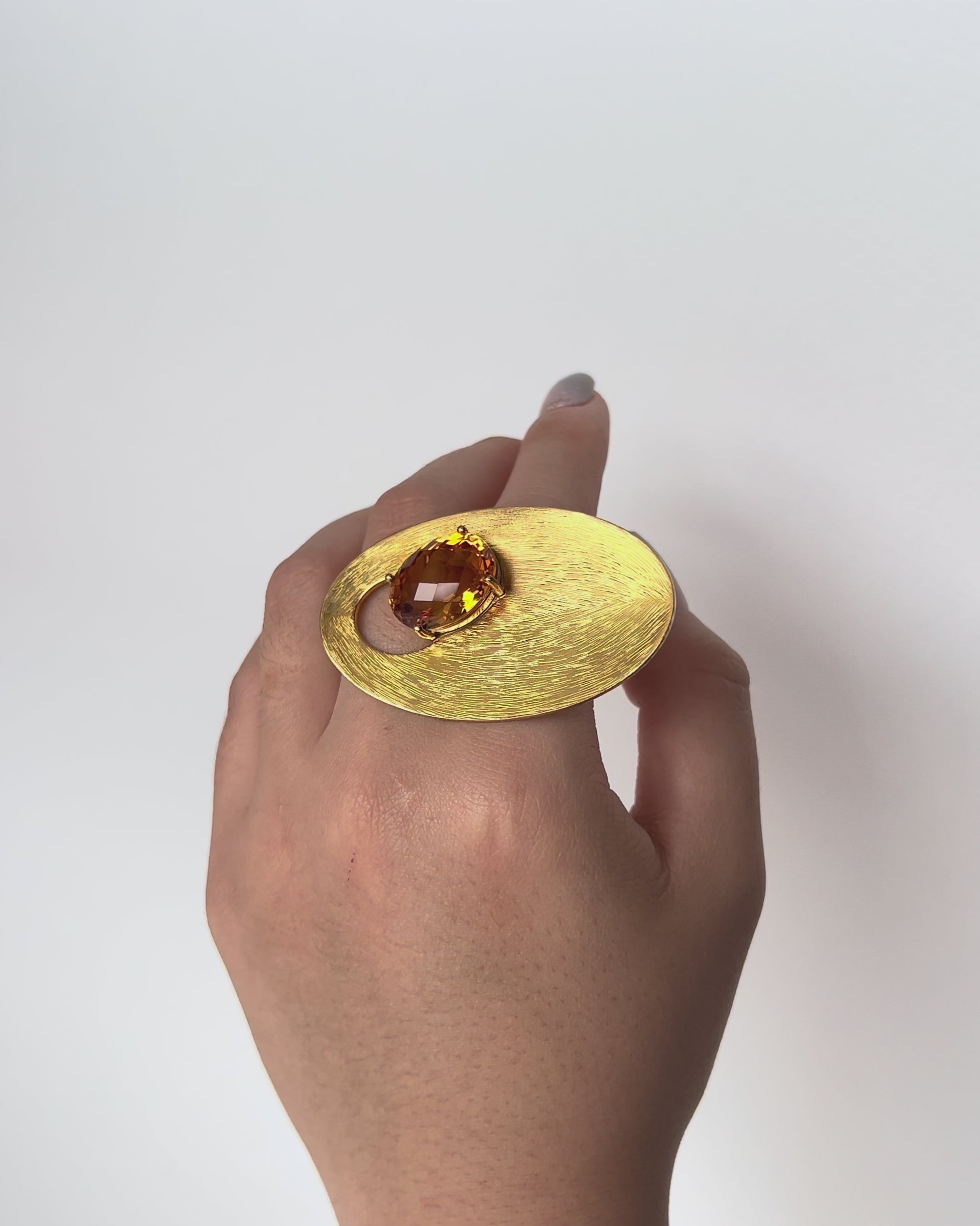 Cosmos Citrine Ring in 9k yellow gold with 12.28ct faceted citrine, curvilinear design inspired by orbital and gravitational forces, worn on hand model.